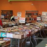 Used books displayed on tables organized by subject.